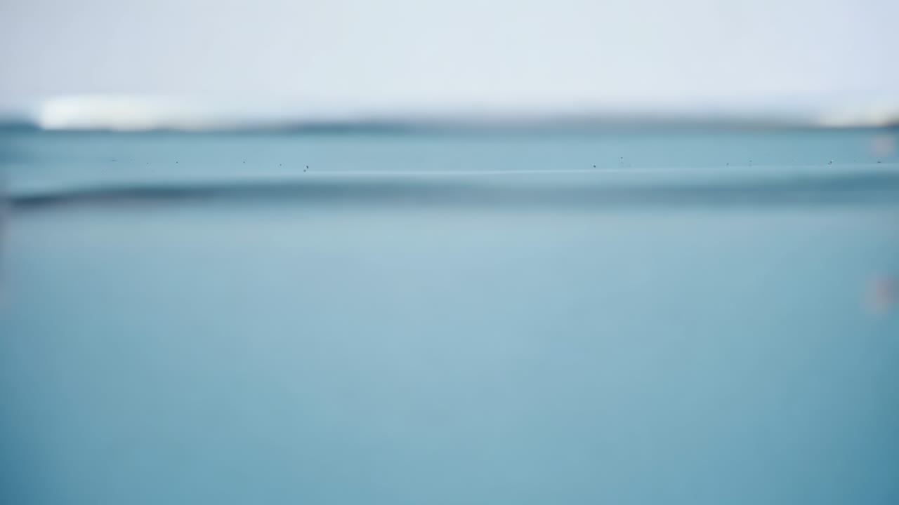Dropping red dye elongating shedding tendrils and mixing tinting water in clear tank, water surface