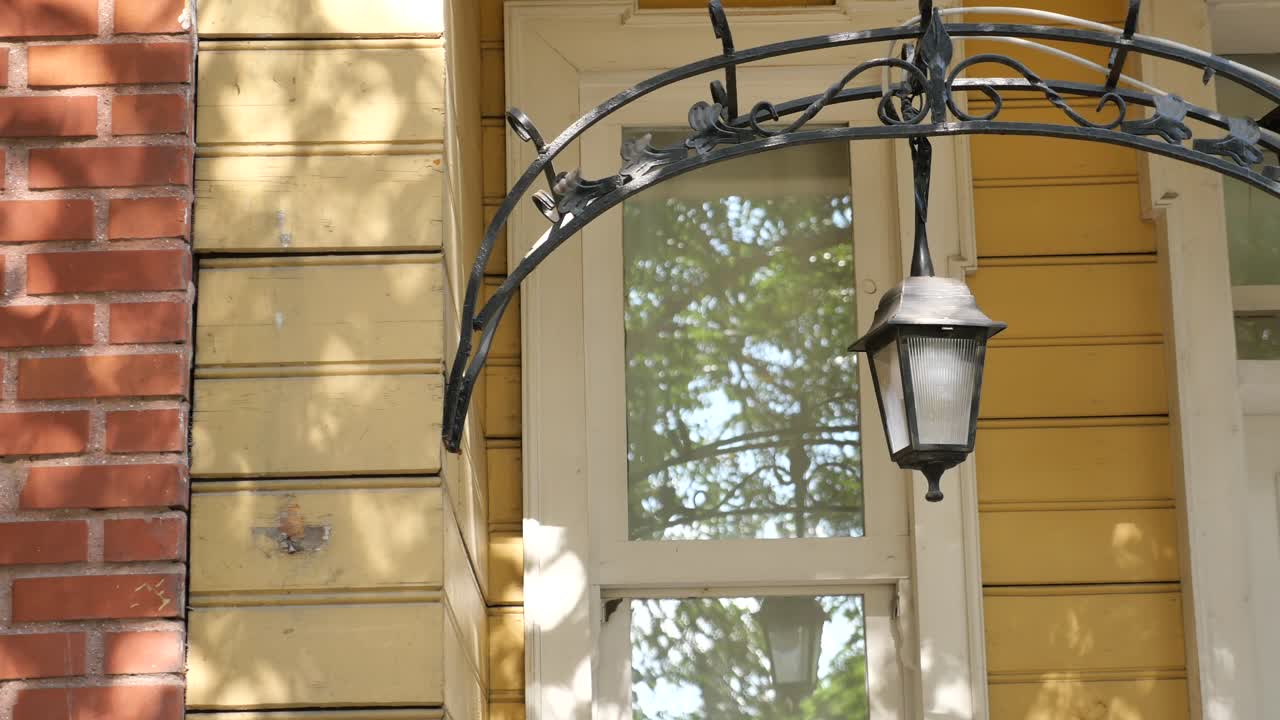 lámpara de hierro forjado vintage en el exterior del edificio amarillo
