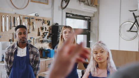 equipo multicultural de aprendices en el taller aprenden a ensamblar un marco de bicicleta construido a mano juntos