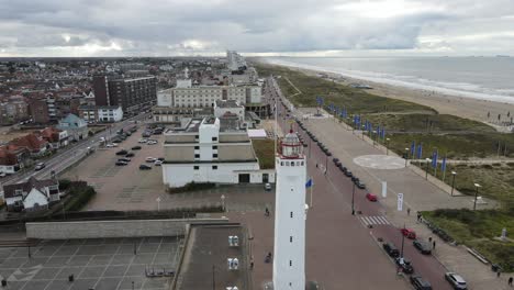 Drone-flying-around-a-lighthouse-near-the-coast-of-Scheveningen,-The-Netherlands