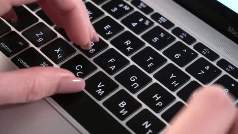 Female-hands-press-keys-on-the-keyboard-of-a-MacBook-with-a-Russian-layout