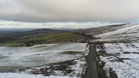 snowy rural winter distant valley countryside aerial agricultural farmland landscape pan left