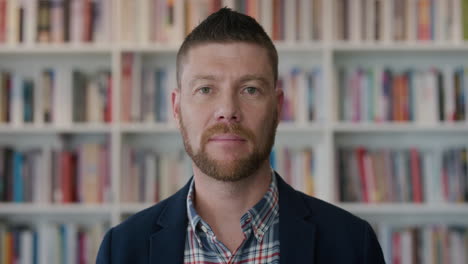 portrait young happy entrerpeneur man smiling enjoying successful bookstore business friendly bearded businessman in bookshelf background slow motion