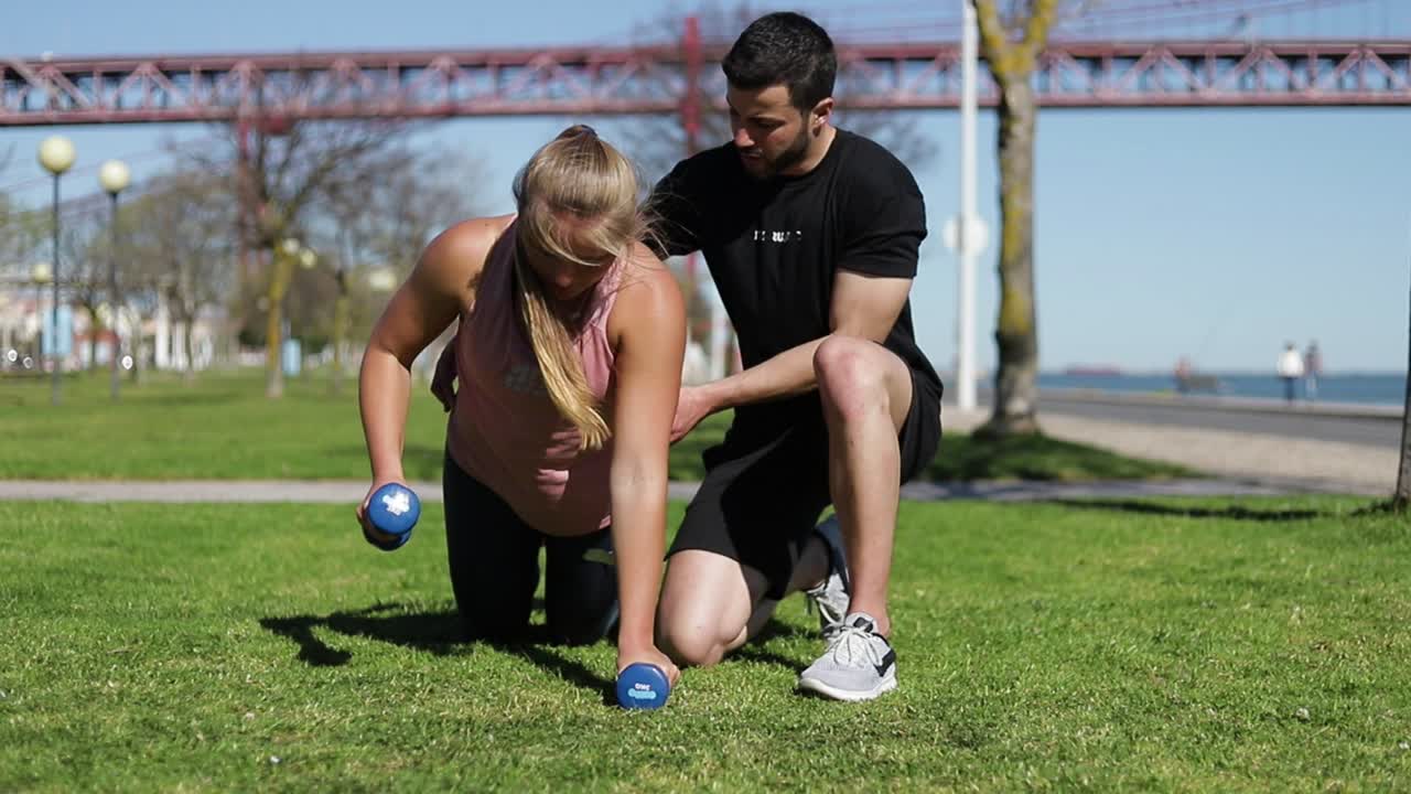 mujer joven deportiva haciendo flexiones con pesas.