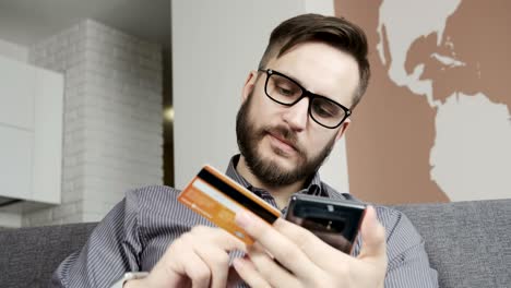 man buying online by smartphone credit bank card