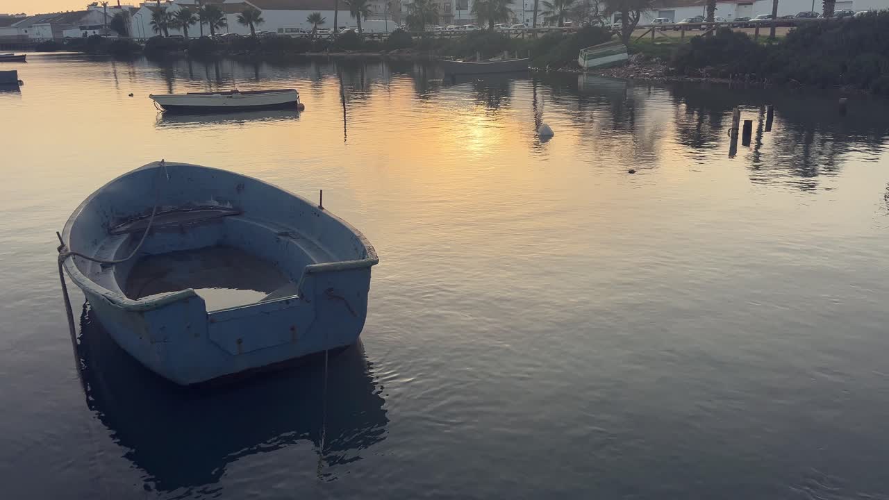 vista estática de un barco amarrado en una bahía con agua en el interior. puesta de sol