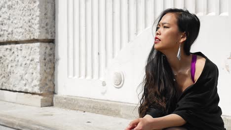 elegant woman sitting by white pillars in vienna's stadtpark, sunlight enhancing her contemplative mood, close-up