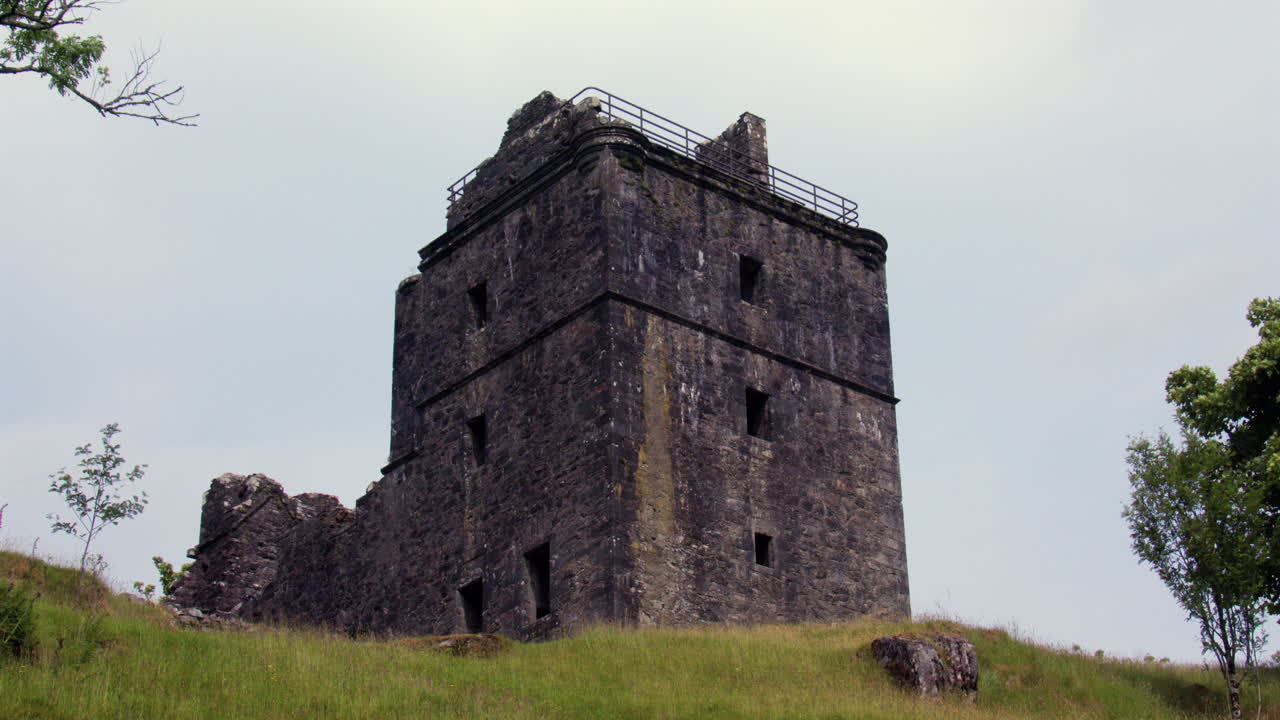 Bredt billede, der ser op ad bakken til Carnasserie Castle, der ligger til venstre for berømmelse