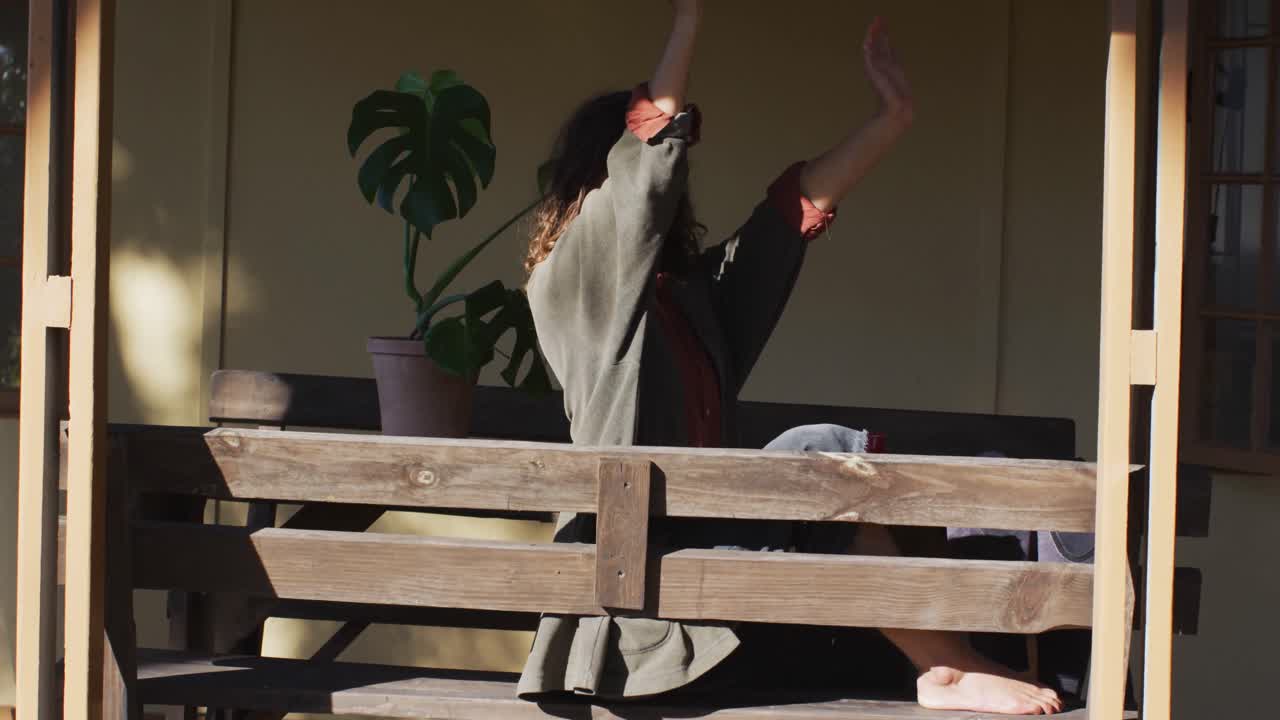 편안한 혼성 인종 여성 앉아서 스트레칭,  ⁇ 은 오두막 거실에서 미소