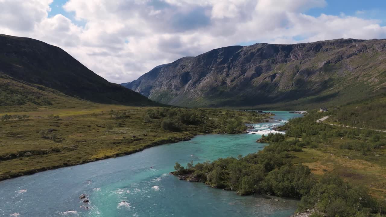 노르웨이 의 산 들 에 둘러싸인 초록색 계곡 을 가로질러 흐르는 푸른색 강 의 공중 사진