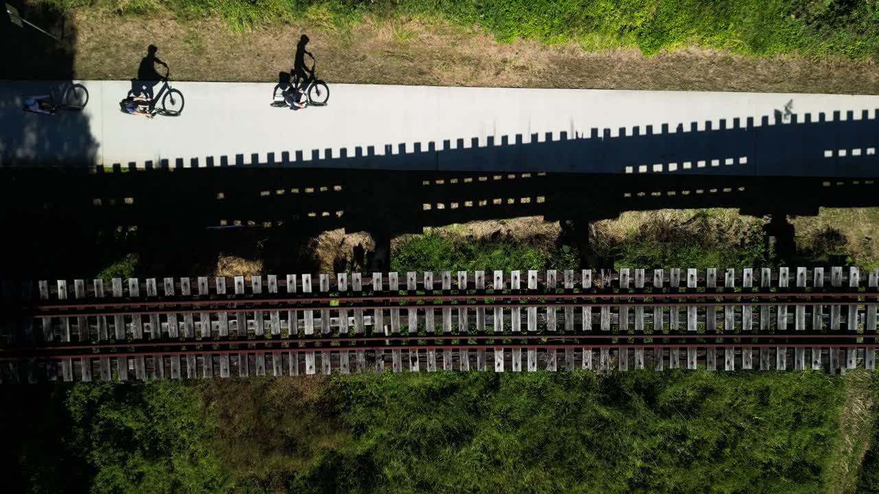 자전거 타는 사람은 오스트레일리아에서 새로 건설된 역사적인 북부 강 철도 트레일의 일부인 오래된 나무 철도 다리를 통과합니다.