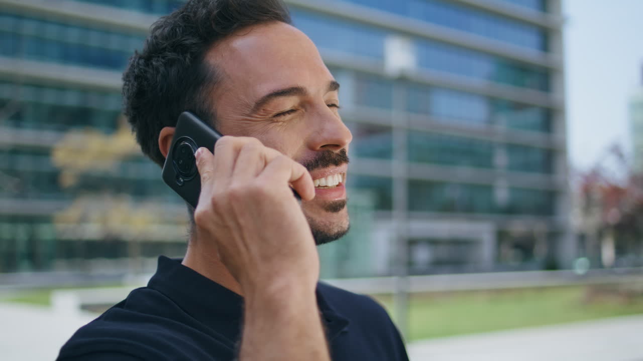 Young businessman calling mobile phone at street closeup. Smiling manager call