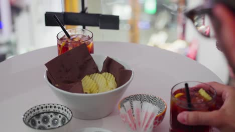 chocolates, drinks, and snacks on the table as friends enjoy a casual moment together