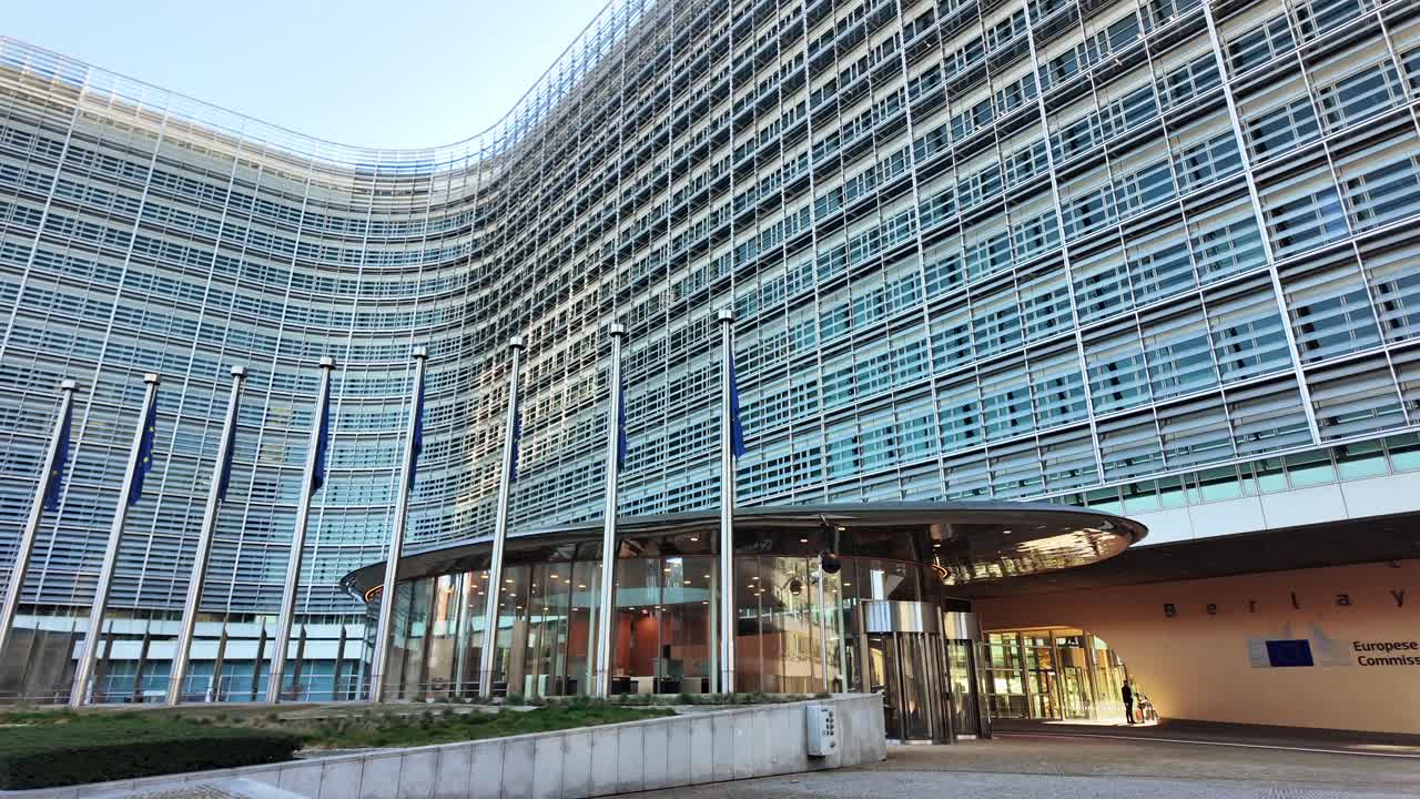 European Commission headquarters with EU flags waving in Brussels