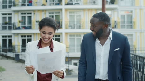 young business team getting good project results outside. couple reading papers