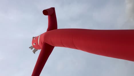 Wacky-waving-red-inflatable-tube-man-on-cloudy-day-slow-motion-portrait-vertical-shot