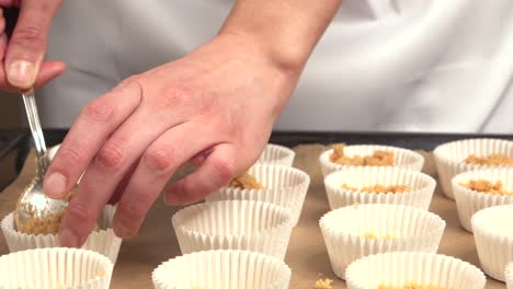 Preparing-cupcakes-arranging-base-in-molds-on-baking-tray