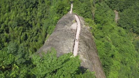 Person-hiking-mountain-steps-up-rocky-Chinese-karst-mountain,-4K-aerial-view