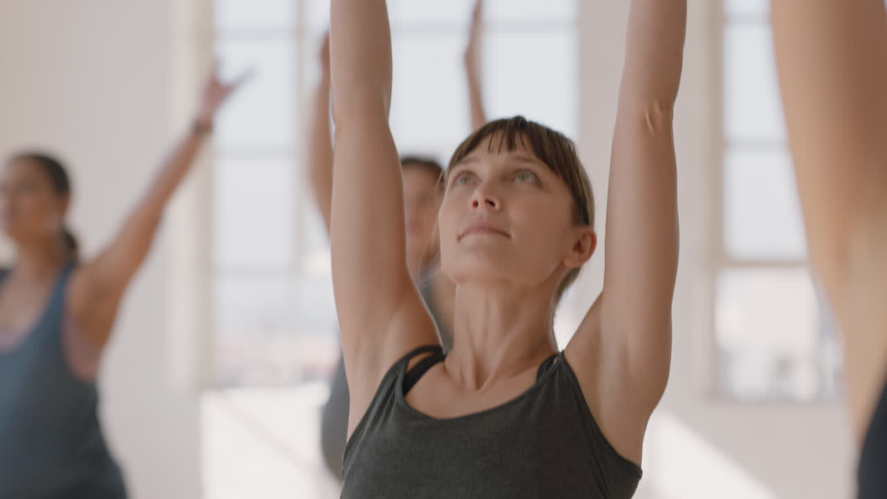 retrato de clase de yoga joven mujer embarazada caucásica practicando poses sosteniendo el vientre disfrutando de ejercicio grupal en el gimnasio