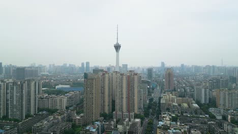 drone accending shot of the west pearl broadcast tower, apartment buildings and busy roads in chengdu on a hazy day