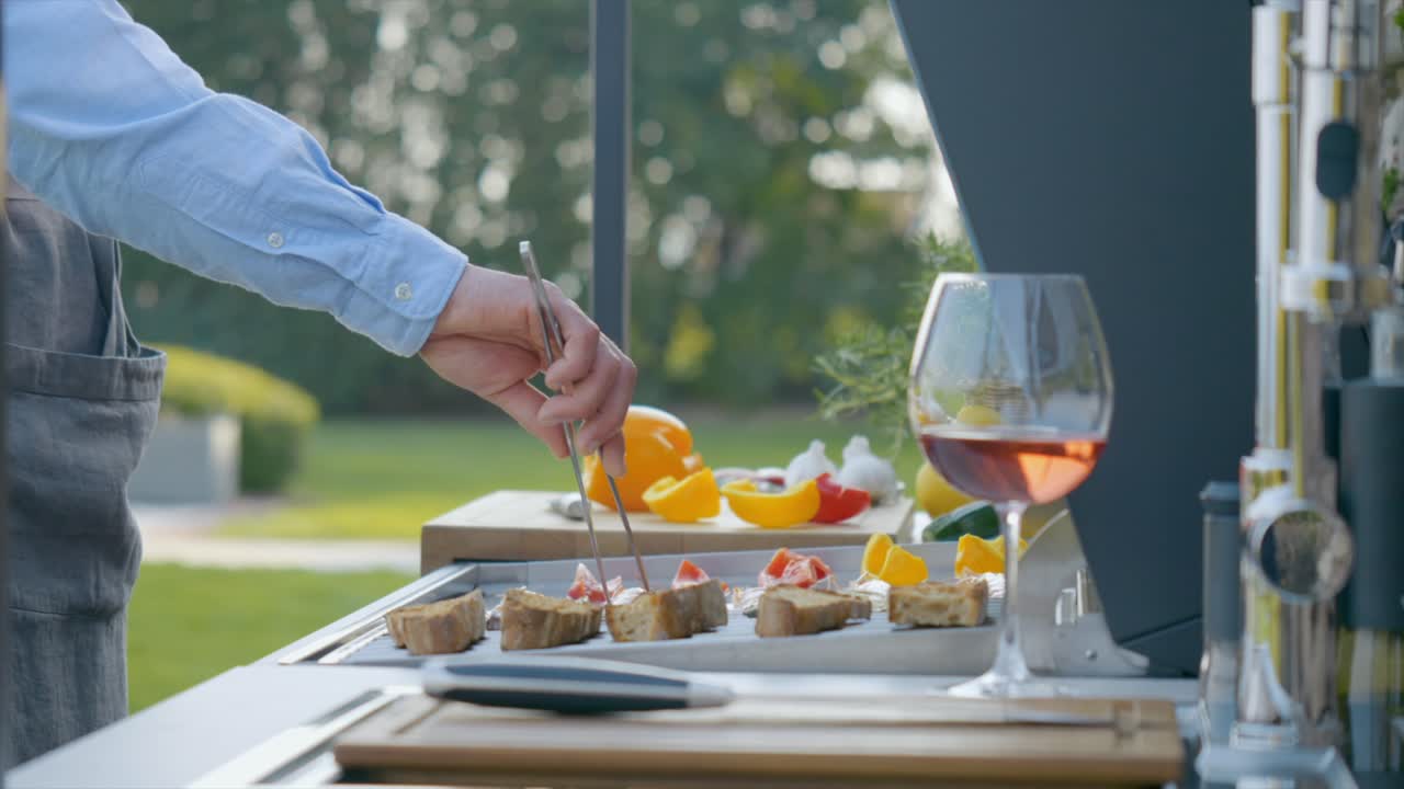 Close Up Shot Of Person Cooking Fresh Food On Grill, With His Glass Of Wine Beside