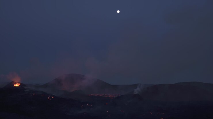 Piccolo aereo che vola sopra la luna piena sopra un'eruzione vulcanica, Islanda