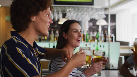 un grupo diverso de amigos felices levantando copas haciendo un brindis en un bar
