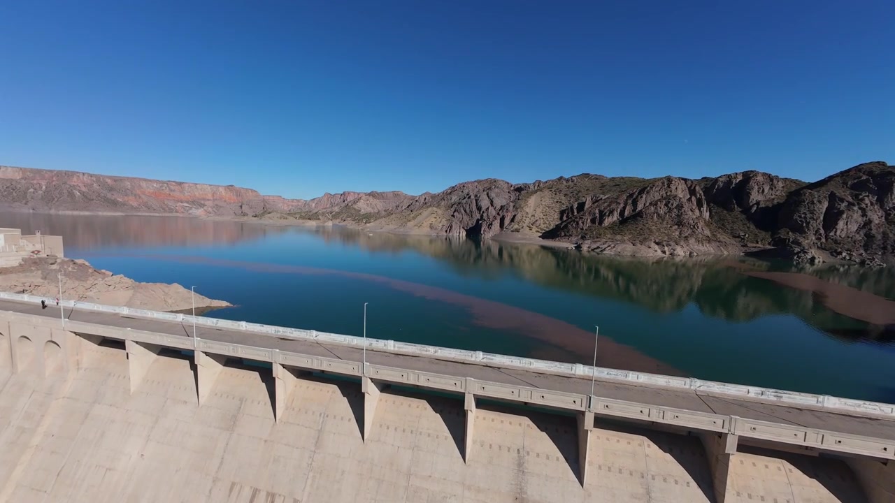 Valle Grande Dam in Atuel Canyon, San Rafael, Mendoza, Argentina, reveals Embalse Valle Grande, hydroelectric infrastructure, freshwater storage and rugged canyon geology, forward flyover reveal shot.