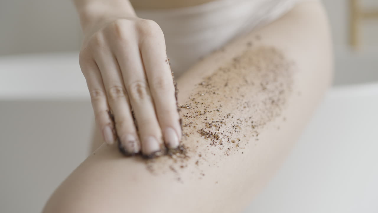 mujer aplicando exfoliante de café a la pierna
