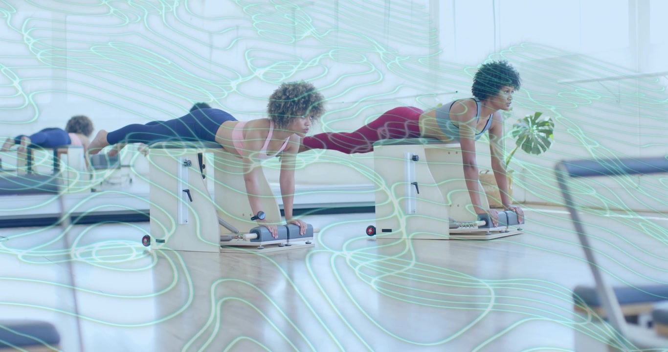 Dva spolužáci vstupují do Pilates studia a provádějí synchronizované plank pulzy na židlích, zapojují střed těla.
