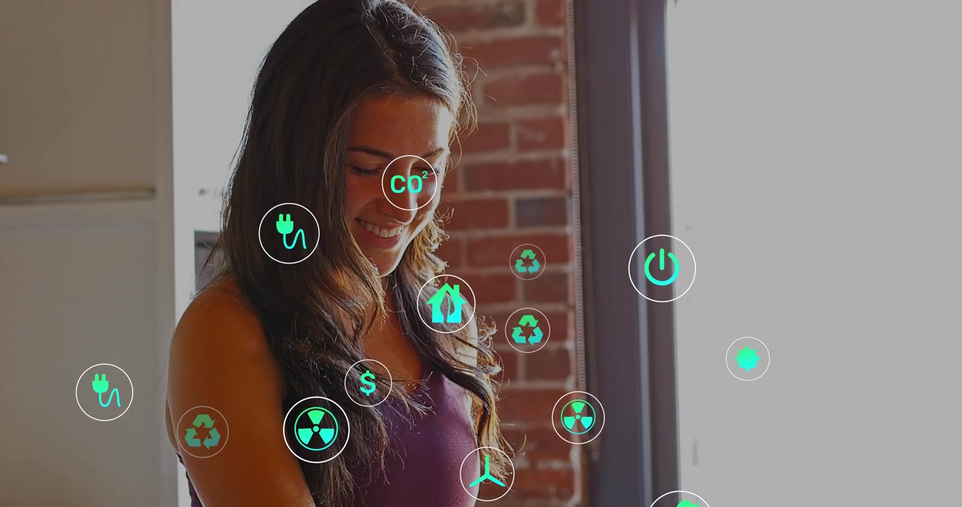 Donna che posa le mani sulla tastiera e visualizza una dashboard energetica, con icone traslucide sovrapposte al laptop