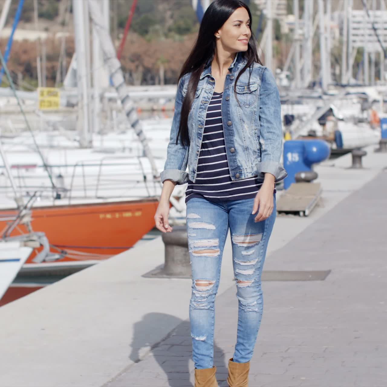 Mujer bonita paseando por un paseo marítimo
