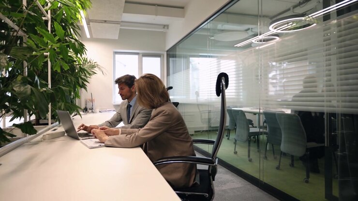 Uomo e donna professionisti che lavorano sui laptop in un ufficio moderno