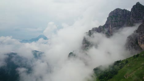 aerial view of floating clouds on side of monte resegone in northern italy