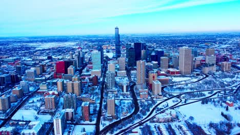 winter aerial flyover downtown edmonton overlooking the buildings from southside to the northside snow covered skyscrapers parks on the skyline with the old airport in the background cleared out1-3