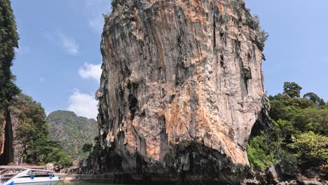 boats navigate around a towering limestone cliff.