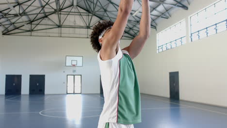 Un-Joven-Birracial-Practica-Baloncesto-En-Una-Cancha-Cubierta.