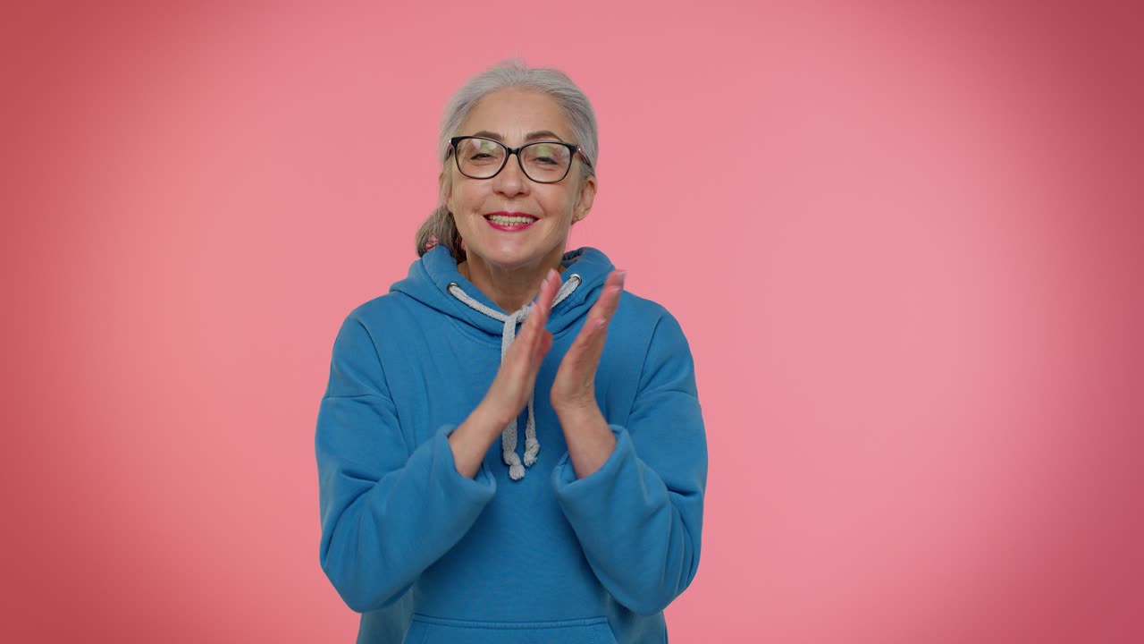 자랑스러운 노인 할머니 할머니는 박수를 치고 승인을 끄덕이며 성공적 인 좋은 일을합니다.