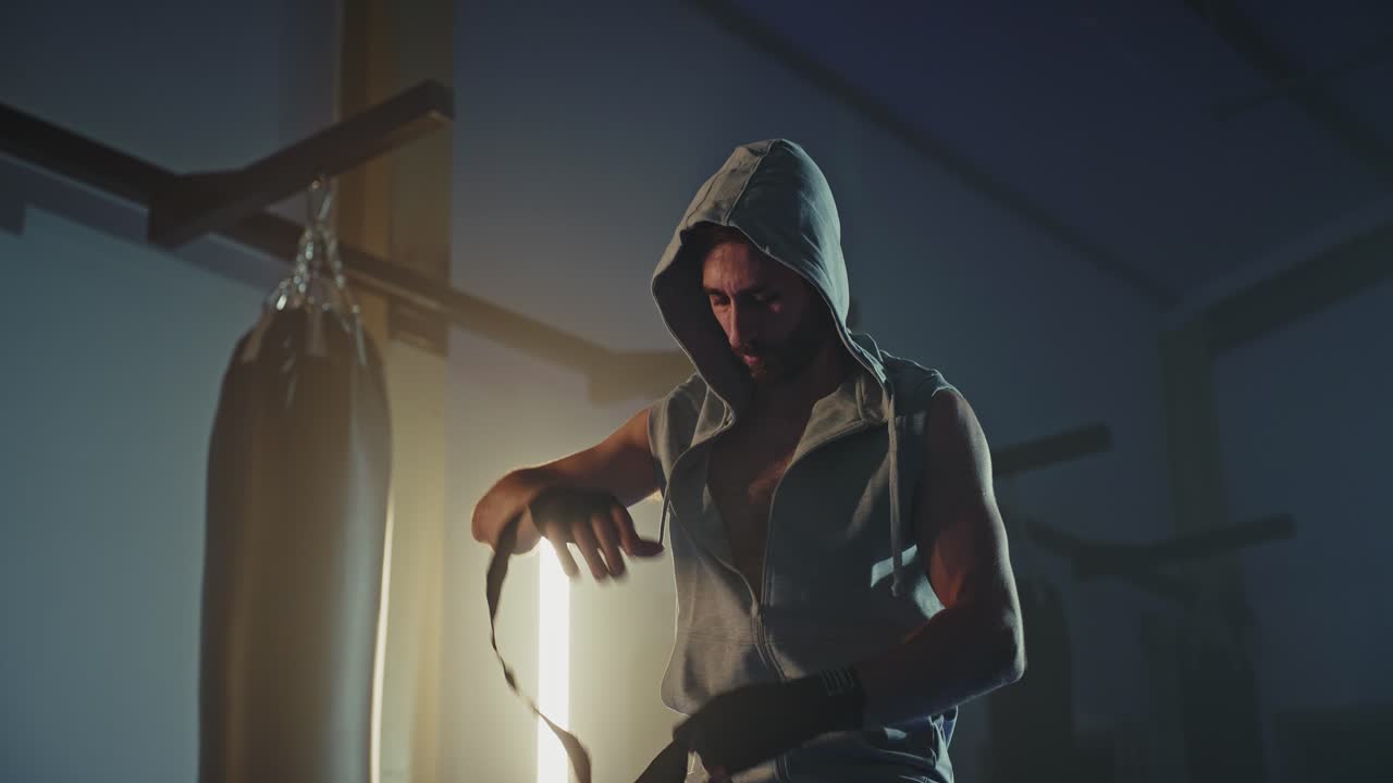 Man Putting on Boxing Wraps in Gym