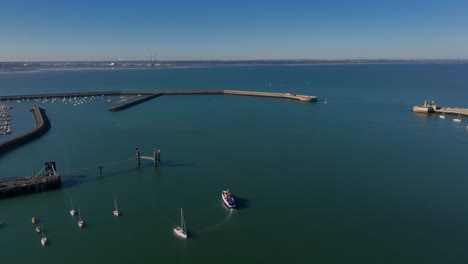 dublin bay cruises boat, dún laoghaire, county dublin, ireland, september 2024. drone panoramic high angle clockwise orbit above the historic harbour with howth and dublin bay in the background