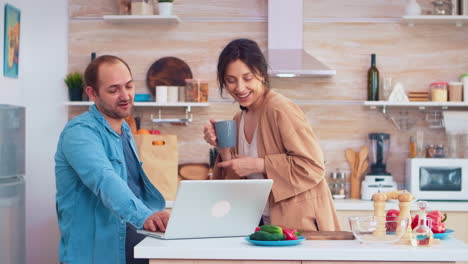 empresario trabajando en una computadora portátil en la cocina