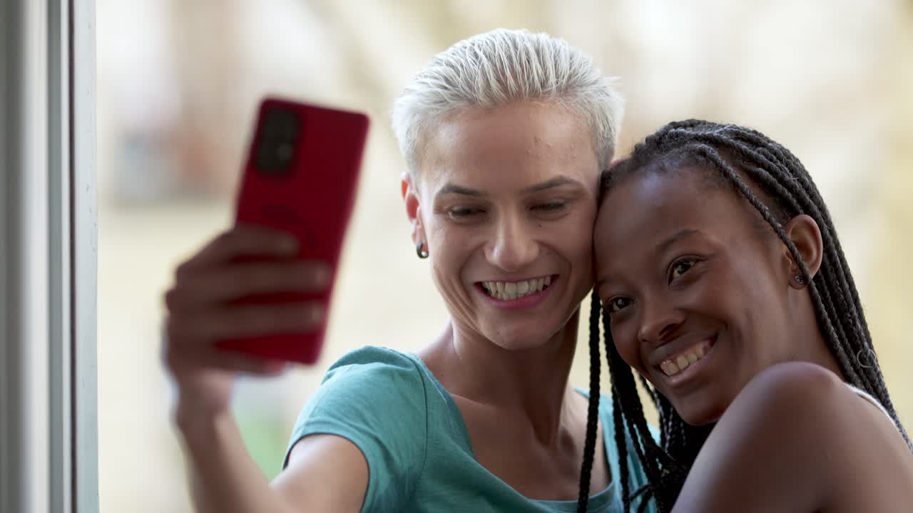 Two happy friends taking a selfie with a mobile phone