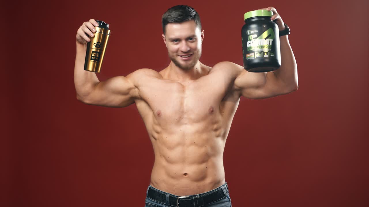 Young athletic guy holding a jar of sports nutrition and a cup. Dieting and sport. Health care and sport concept.