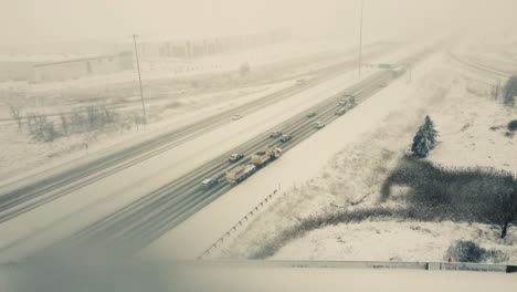 aerial forward view over vehicles running on a highway in a snow