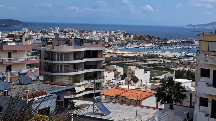 Panorâmica aérea de uma cidade costeira com um porto e oceano azul