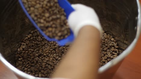 employee is taking roasted coffee beans and put them on the package ready for shipment