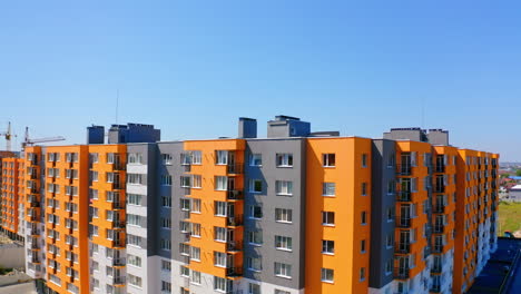 bright multi-storey building in sunny day. modern design of high-rise apartment building in the city. exterior of new block of flats for residents under blue sky.