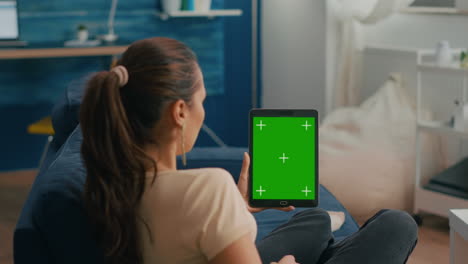 business woman looking at tablet computer with mock up green screen chroma key display