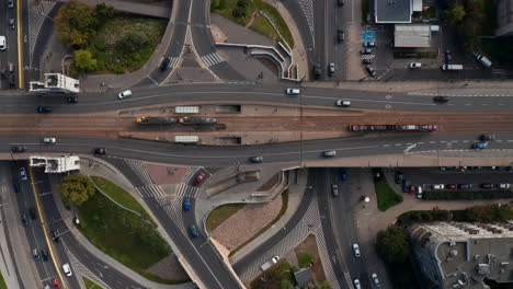 Aerial-birds-eye-overhead-top-down-view-of-heavy-traffic-on-road-intersection.-Trams-at-tram-stop.-Warsaw,-Poland