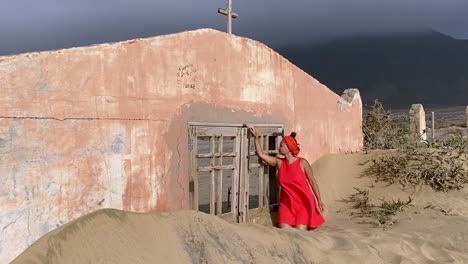 A-woman-in-a-red-dress-looks-inside-a-small-church-in-Fuerteventura